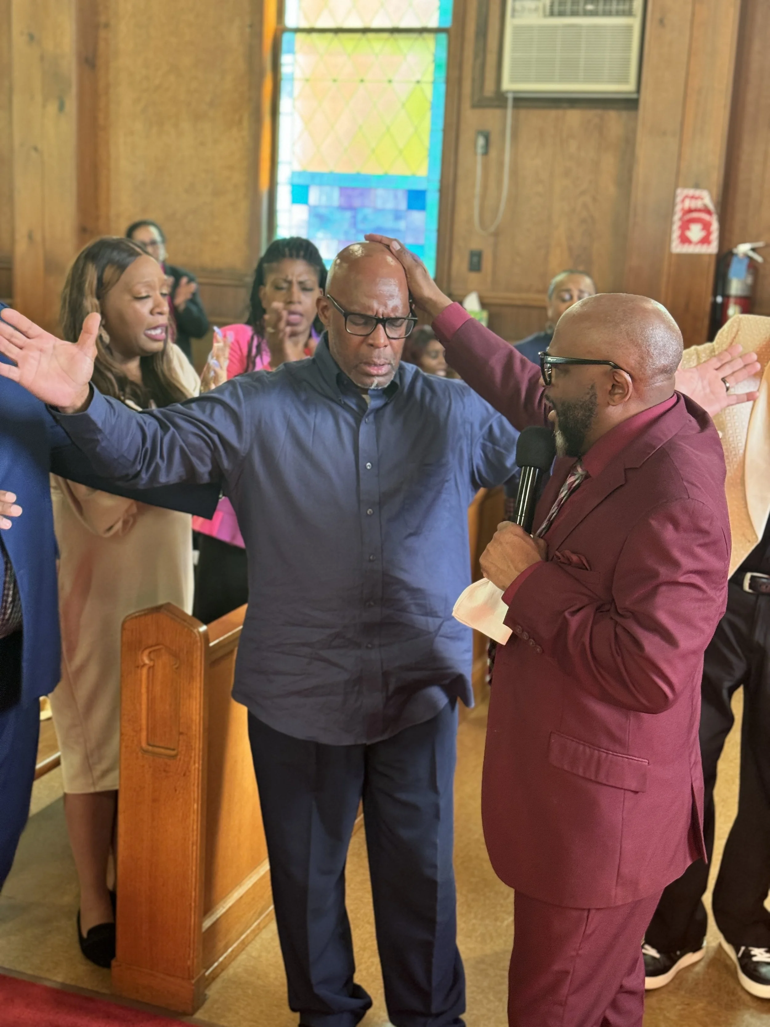 Members of Love Fellowship Temple pray together during worship.