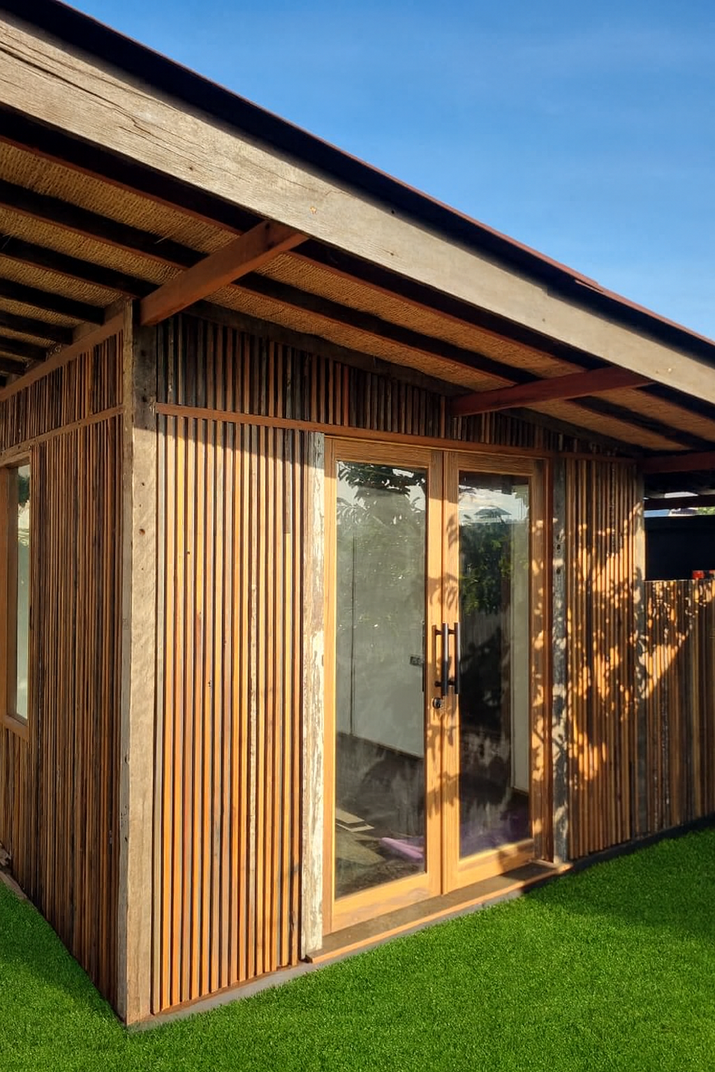Reclaimed wood slatted panel wall used as an architectural screen