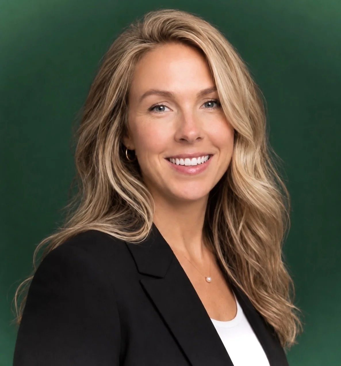 Emily, nourishED co-founder, smiling headshot against a green background.