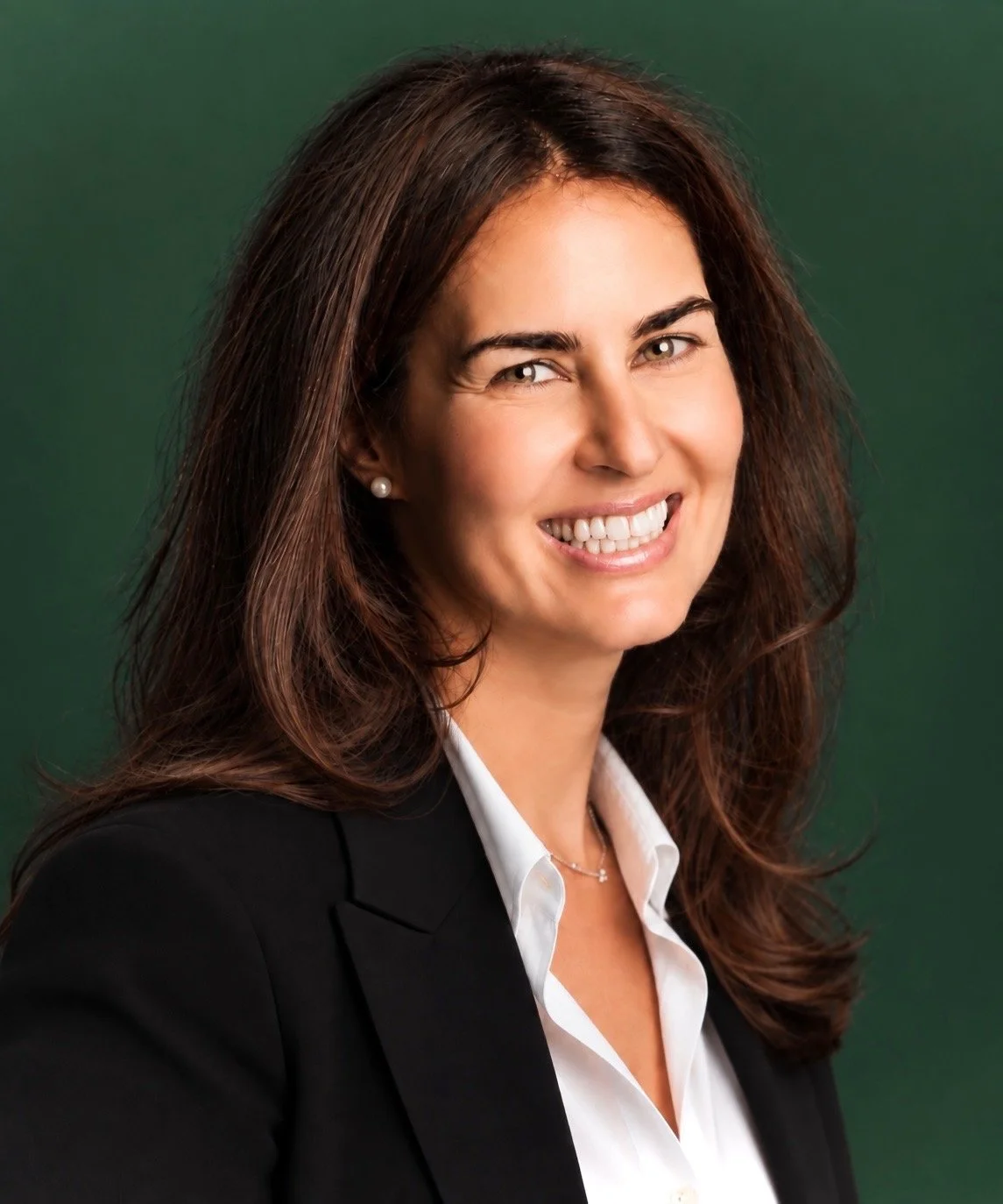 Golnaz, nourishED co-founder, smiling headshot against a green background.