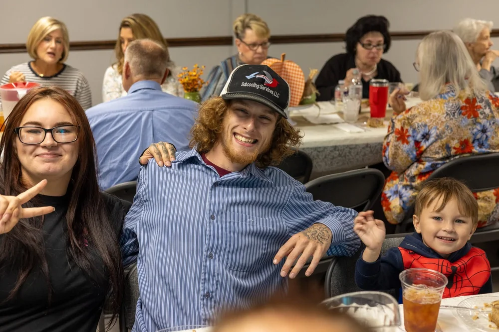 Friends laughing around a dinner table