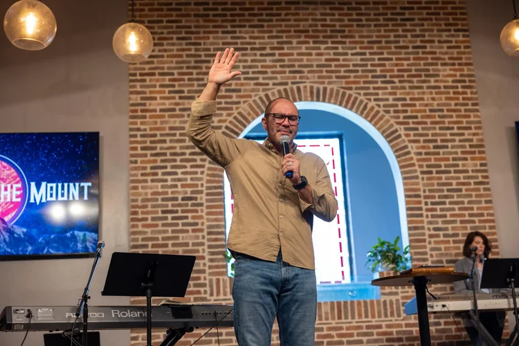 Pastor Simon waving from the stage