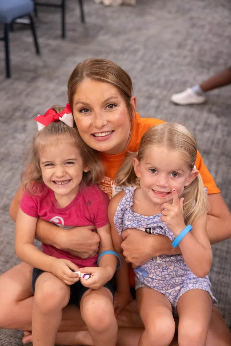 A Faith Kids leader with two smiling girls