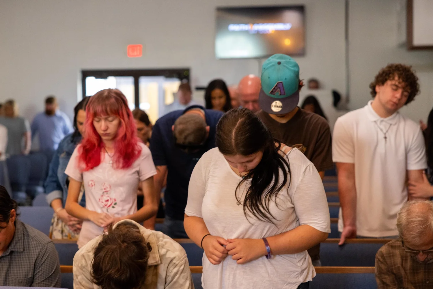 People praying with heads bowed
