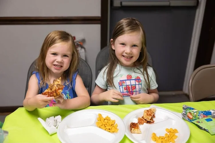 Two girls smiling at lunch