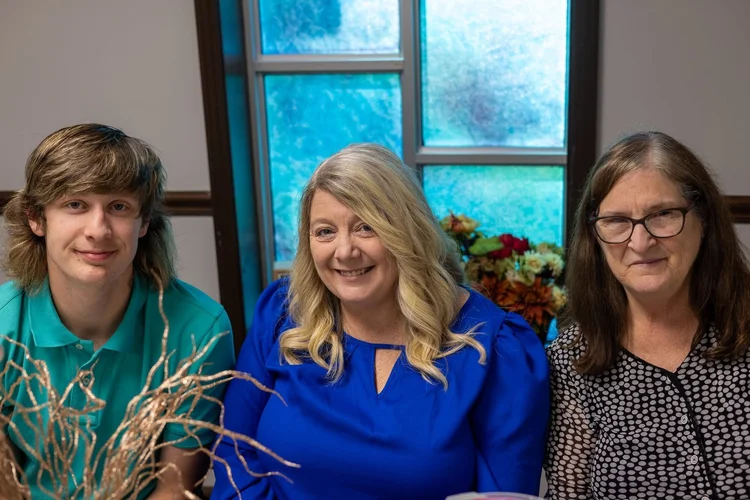 Three friends smiling at a fall dinner