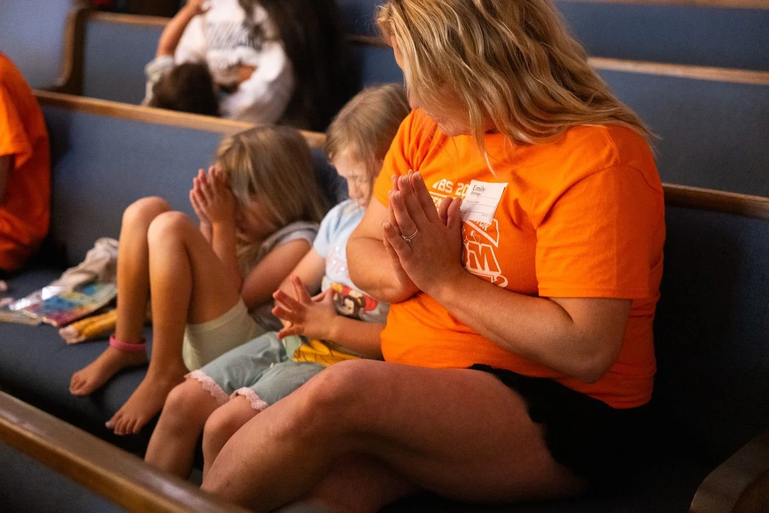 A leader praying with children