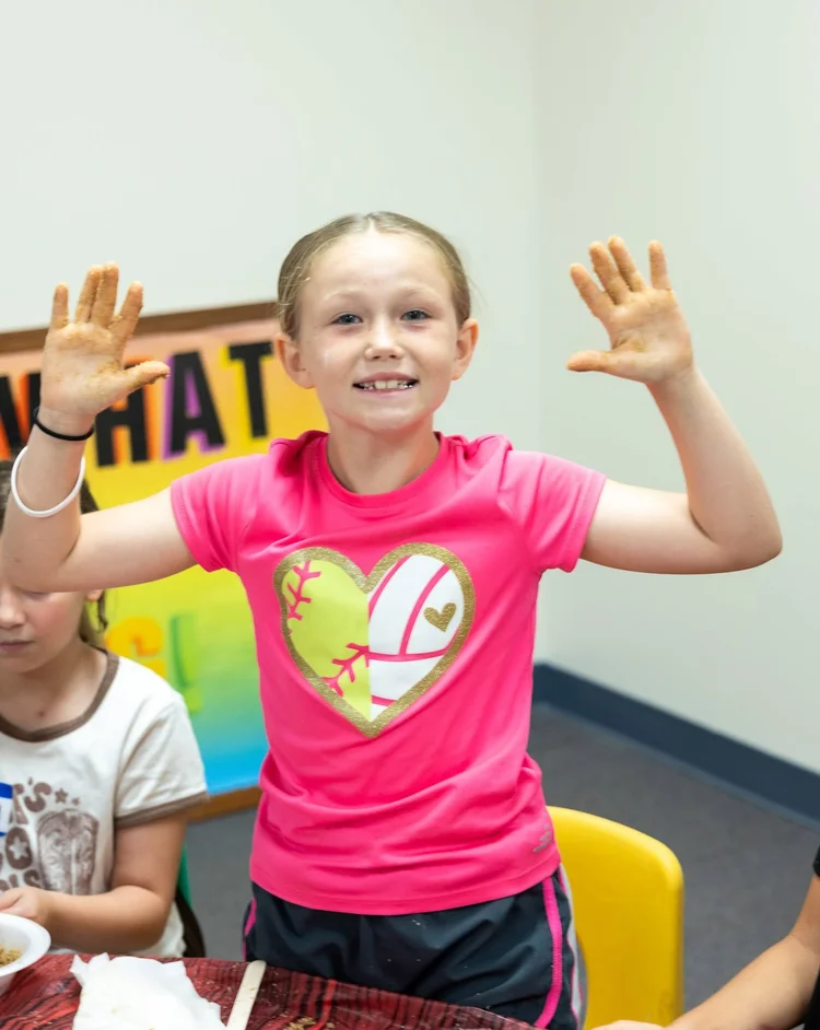 A girl cheering with both hands up