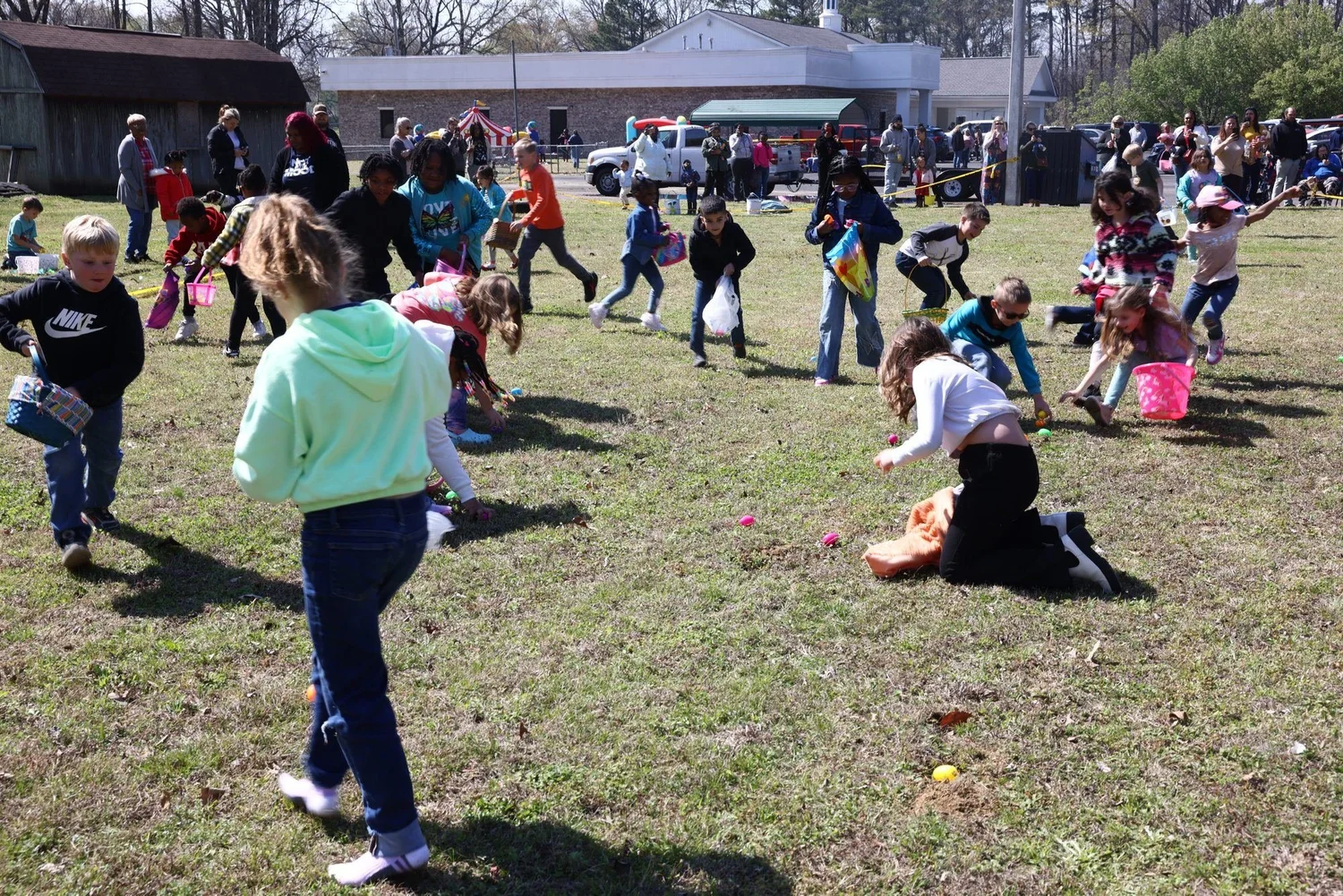 Dozens of kids running across the field at the Easter egg hunt