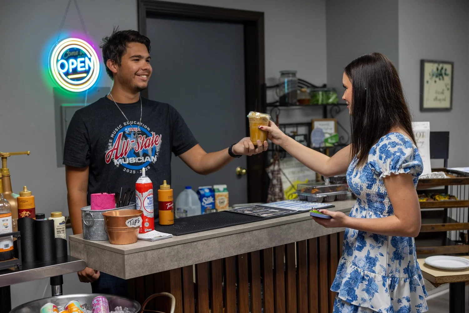 A barista handing a guest a drink at the Faith Assembly coffee bar