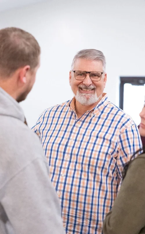 Two men greeting each other with a smile