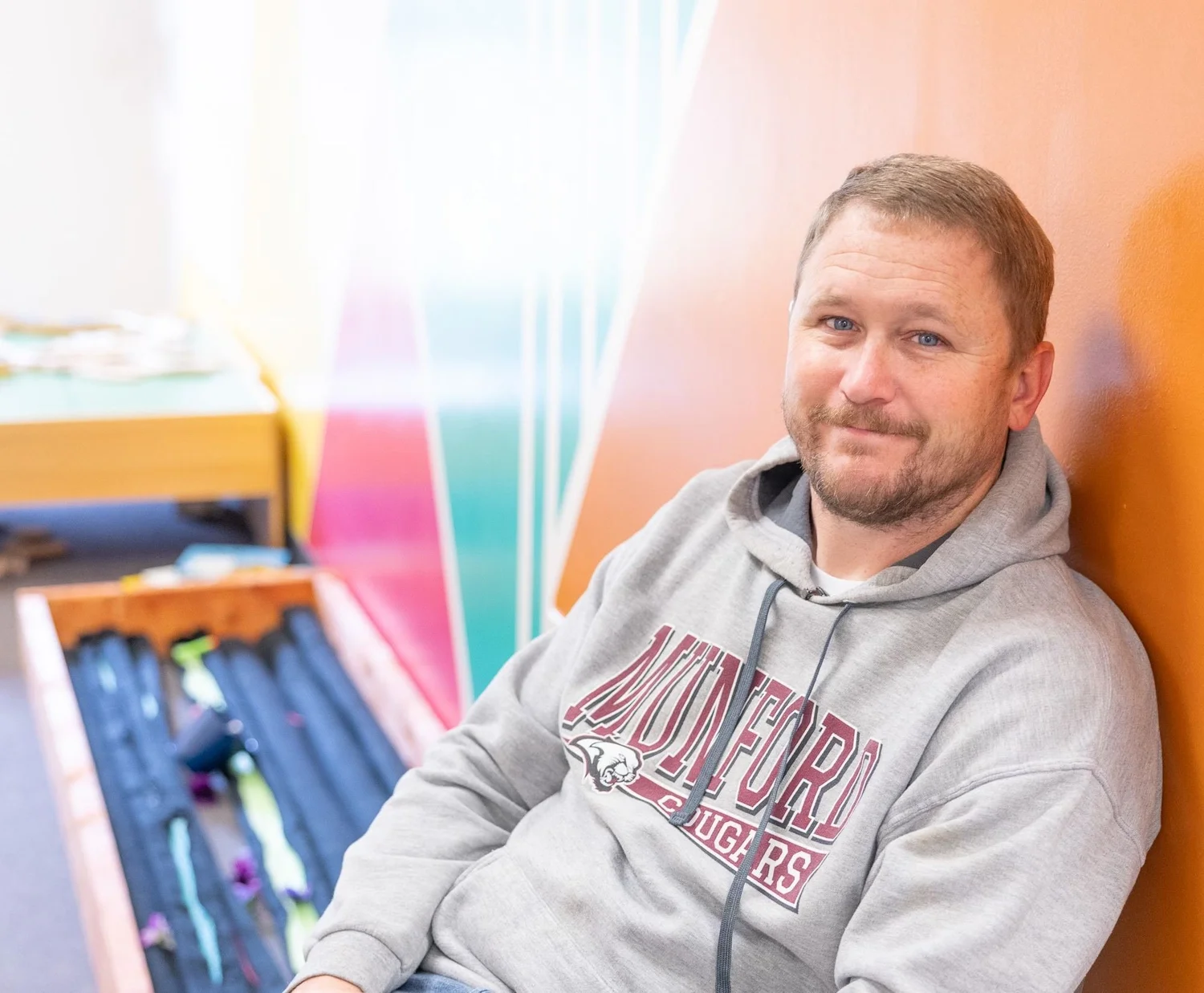 A man smiling in the kids hallway