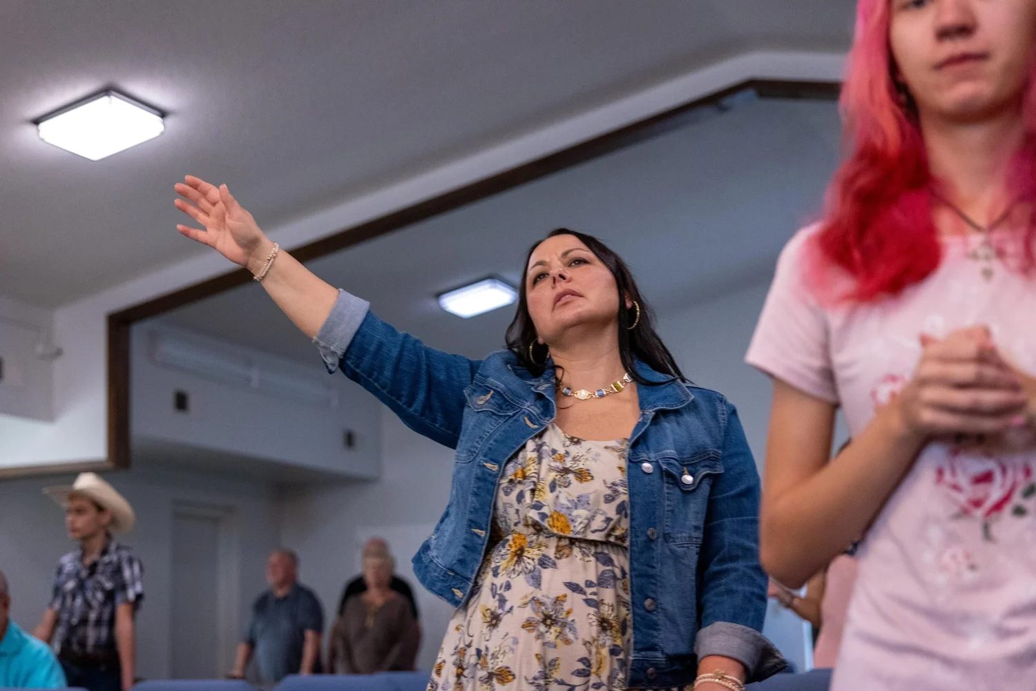 A woman worshiping with her hand raised