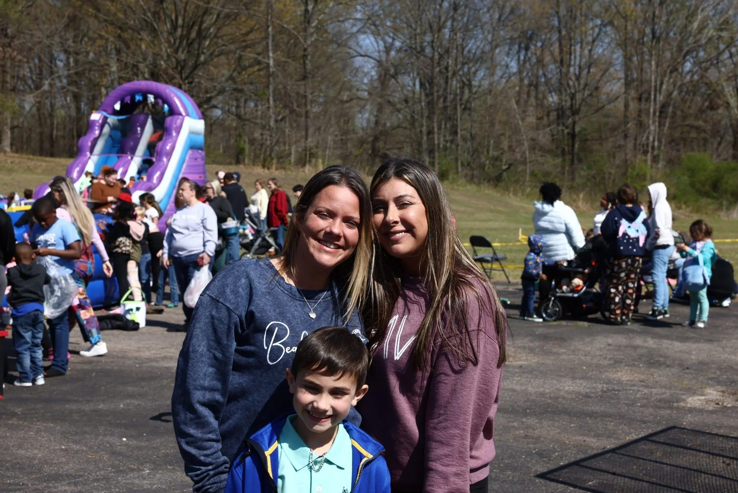 Two women and a boy smiling at the outreach