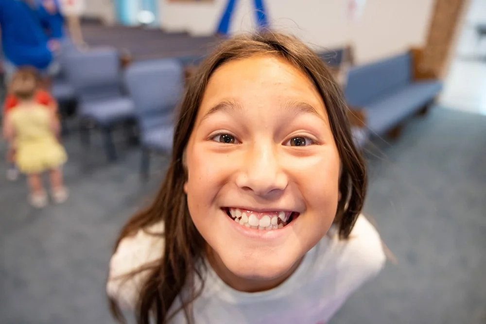 A girl grinning at the camera during VBS