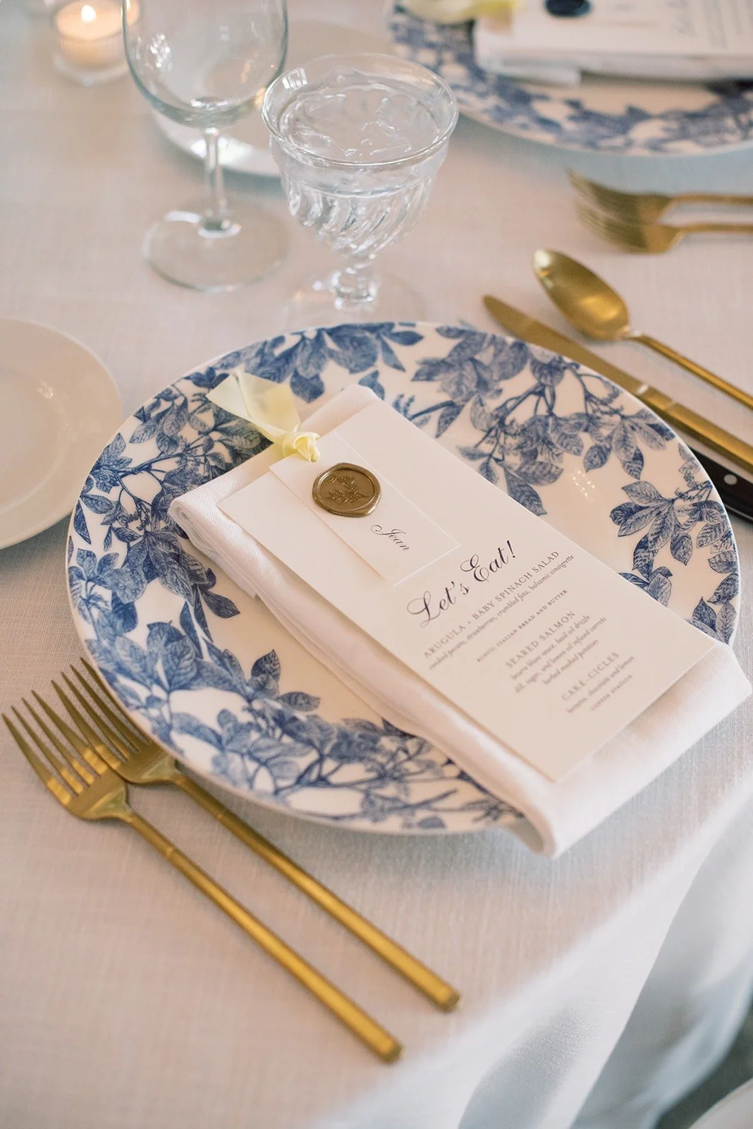 Blue patterned china and a wedding menu, supplied by Light as a Feather Events