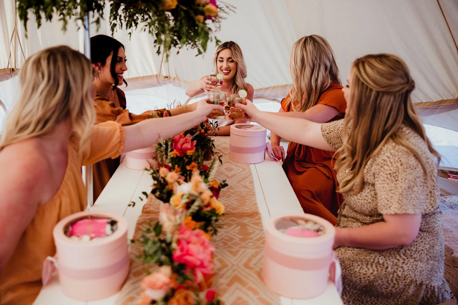 Friends raising their glasses around a flower-filled table