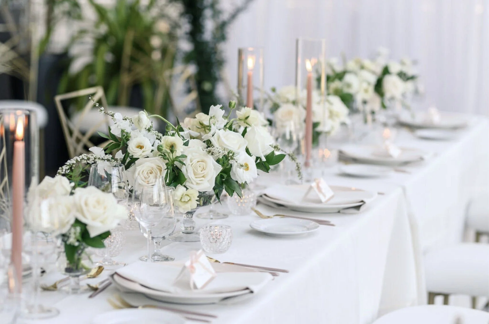 White flowers and candlelight along a reception table, supplied by Light as a Feather Events