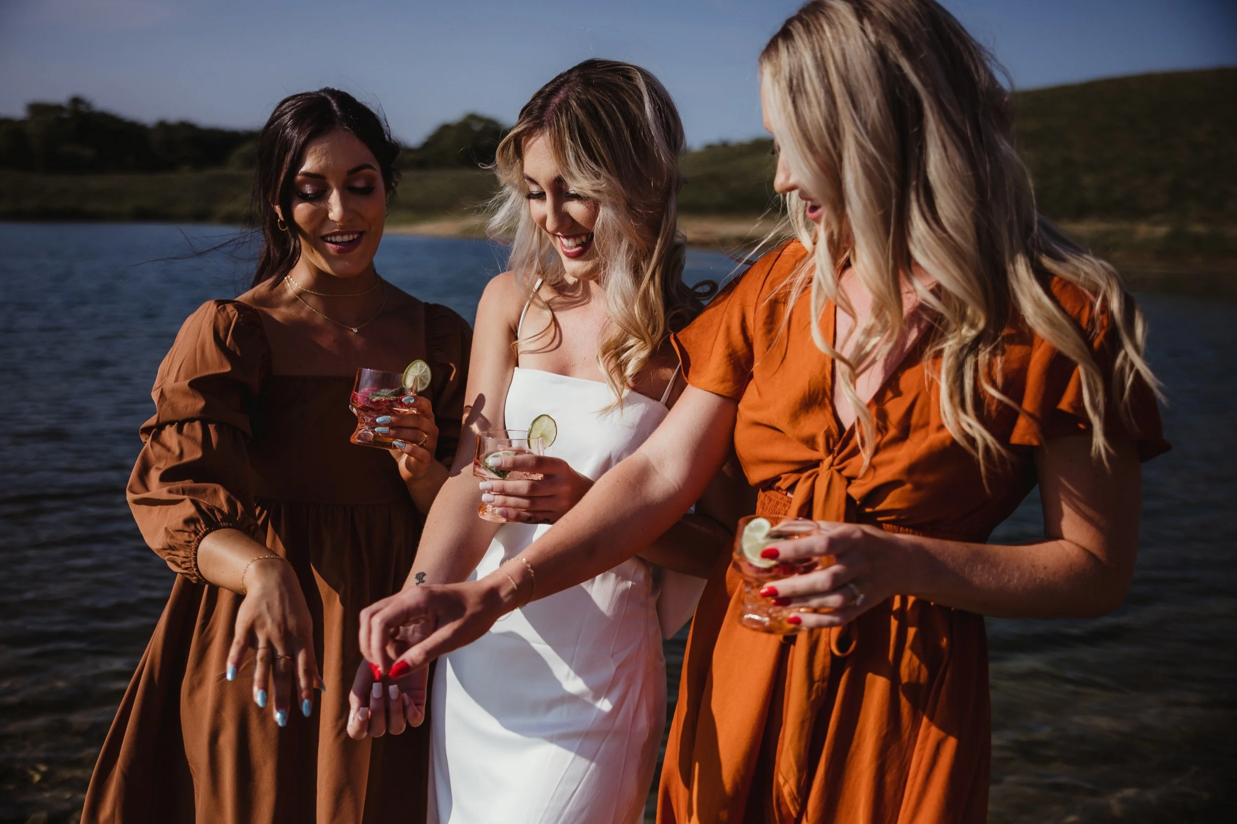 Friends gathered with drinks beside the water