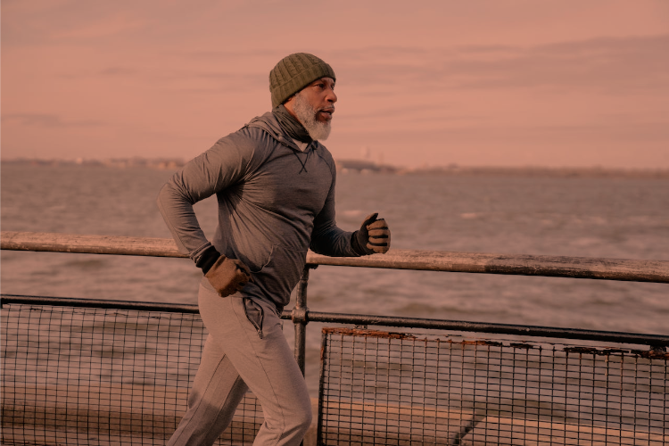 Mid-fifties man jogging along waterfront with view of the ocean