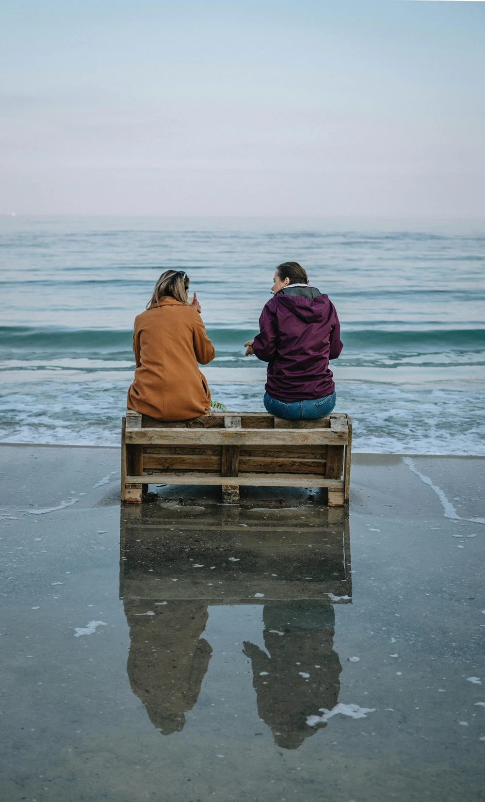 Two women in conversation by the sea