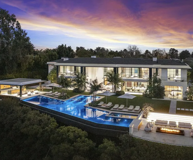Aerial of a modern two-story estate with pool and cabana at dusk