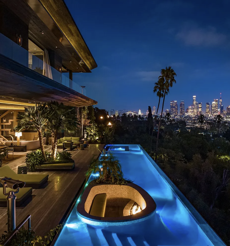 Hillside terrace and infinity pool overlooking the downtown Los Angeles skyline at night