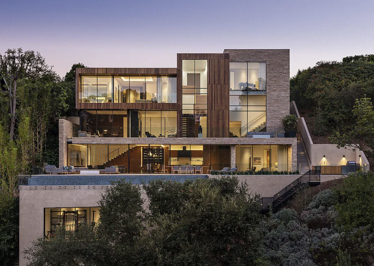 Three-level hillside modern with cantilevered terraces at dusk