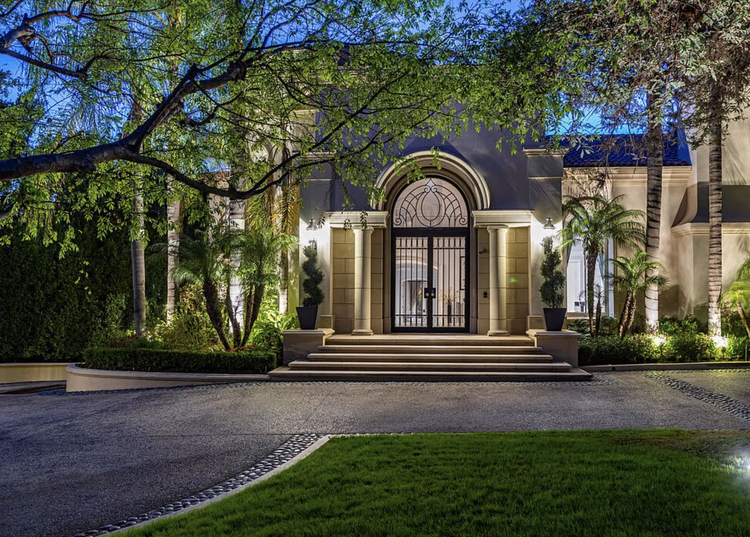 Ornate gated entrance with arched ironwork at dusk