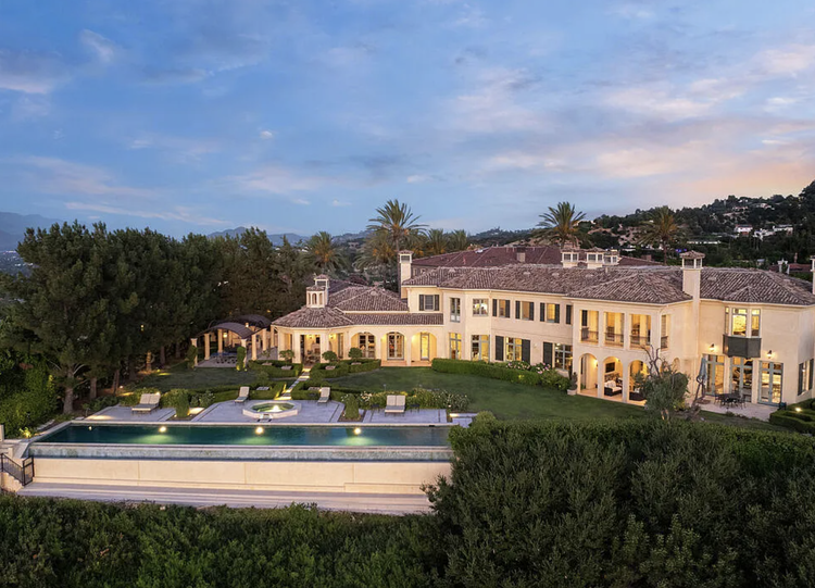 Mediterranean estate with lawn and long pool at dusk