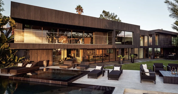 Dark wood-clad modern with terrace lounge and pool at dusk