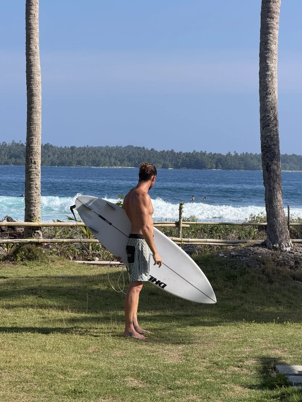 Mike Watts with his surfboard looking out at the waves