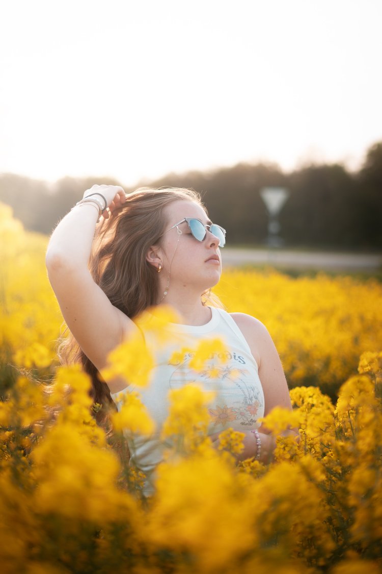 Outdoor portrait in a field of yellow flowers
