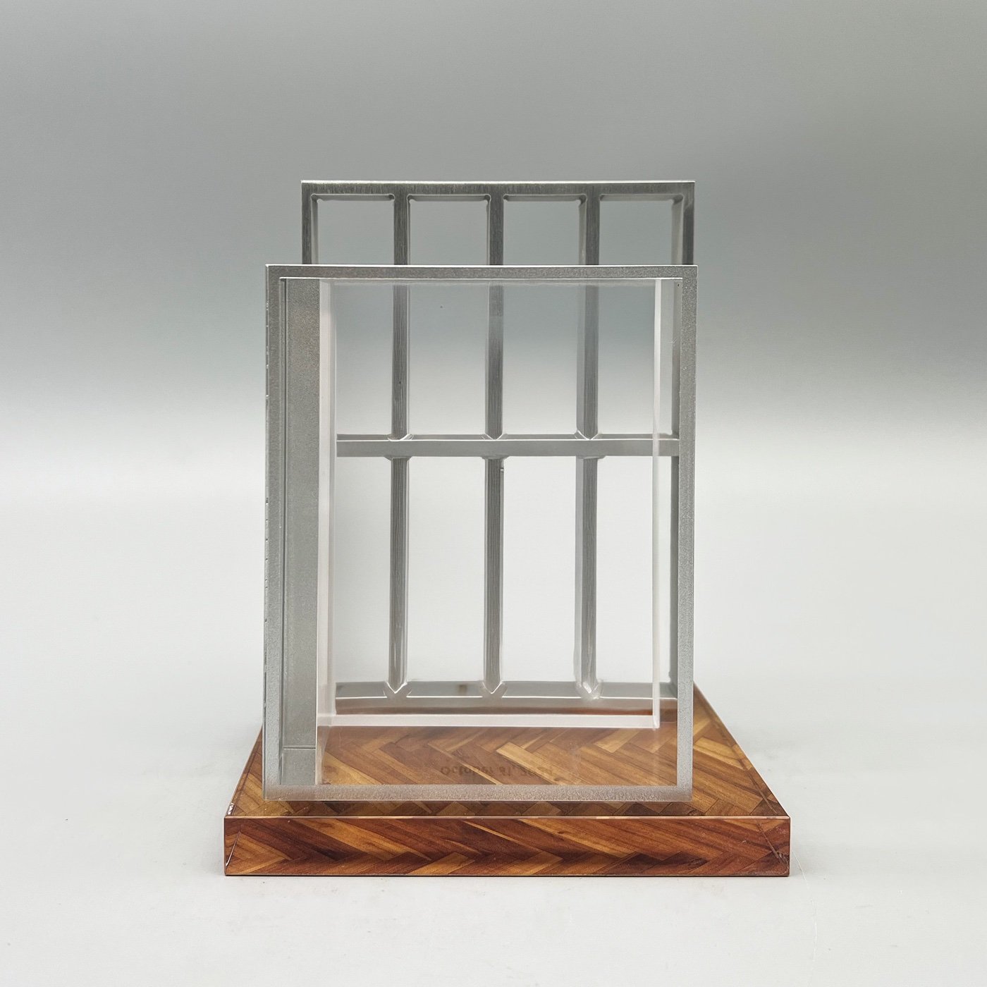 Dimensional deal marker with silver window-frame forms and a clear panel on a wood-patterned base.
