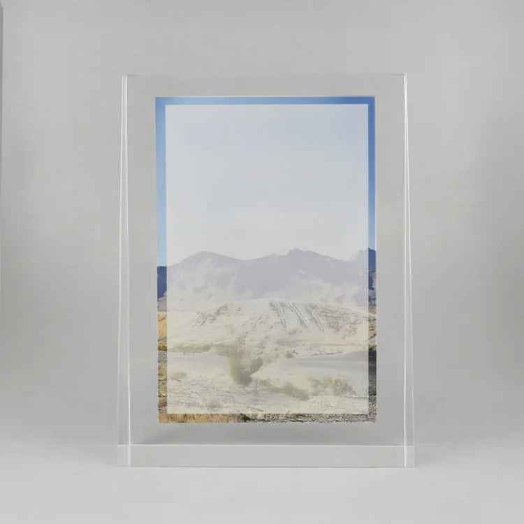 Clear rectangular commemorative displaying a desert landscape photograph with a blue border.