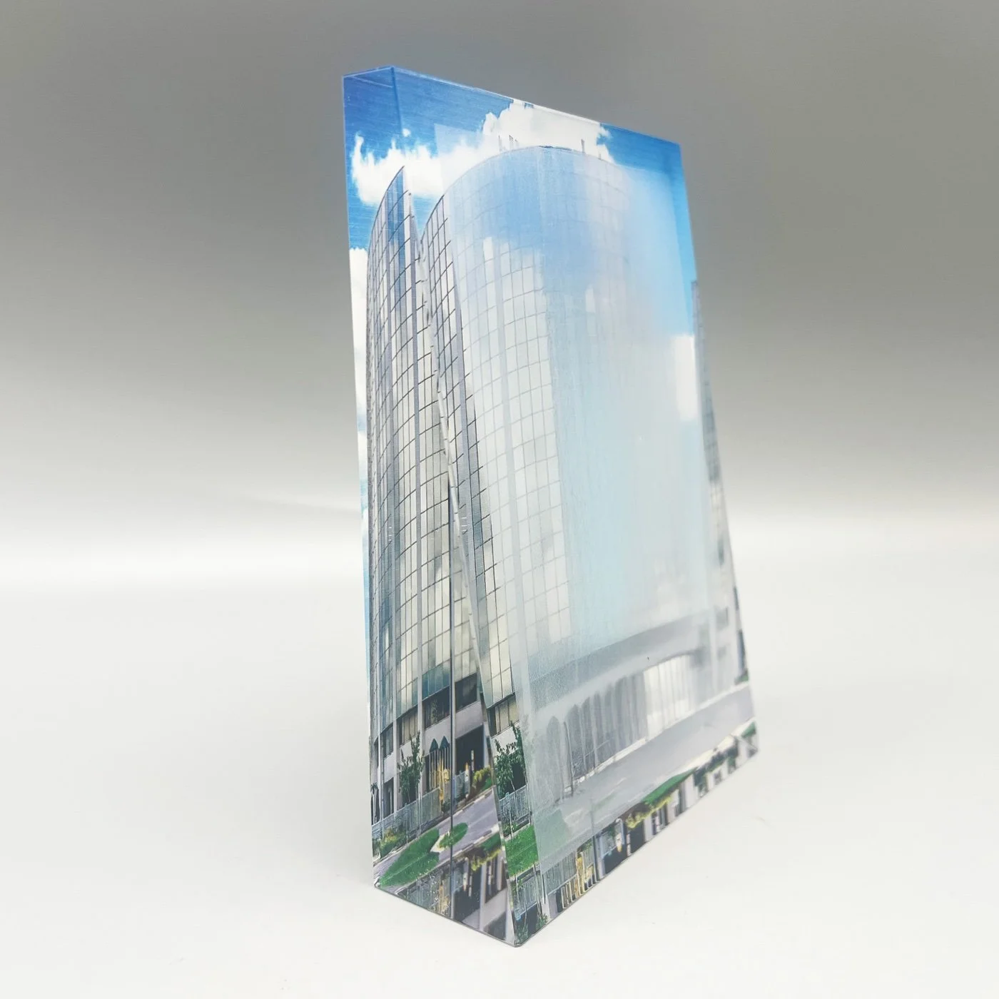 Clear rectangular deal toy displaying a photograph of a curved glass office tower.