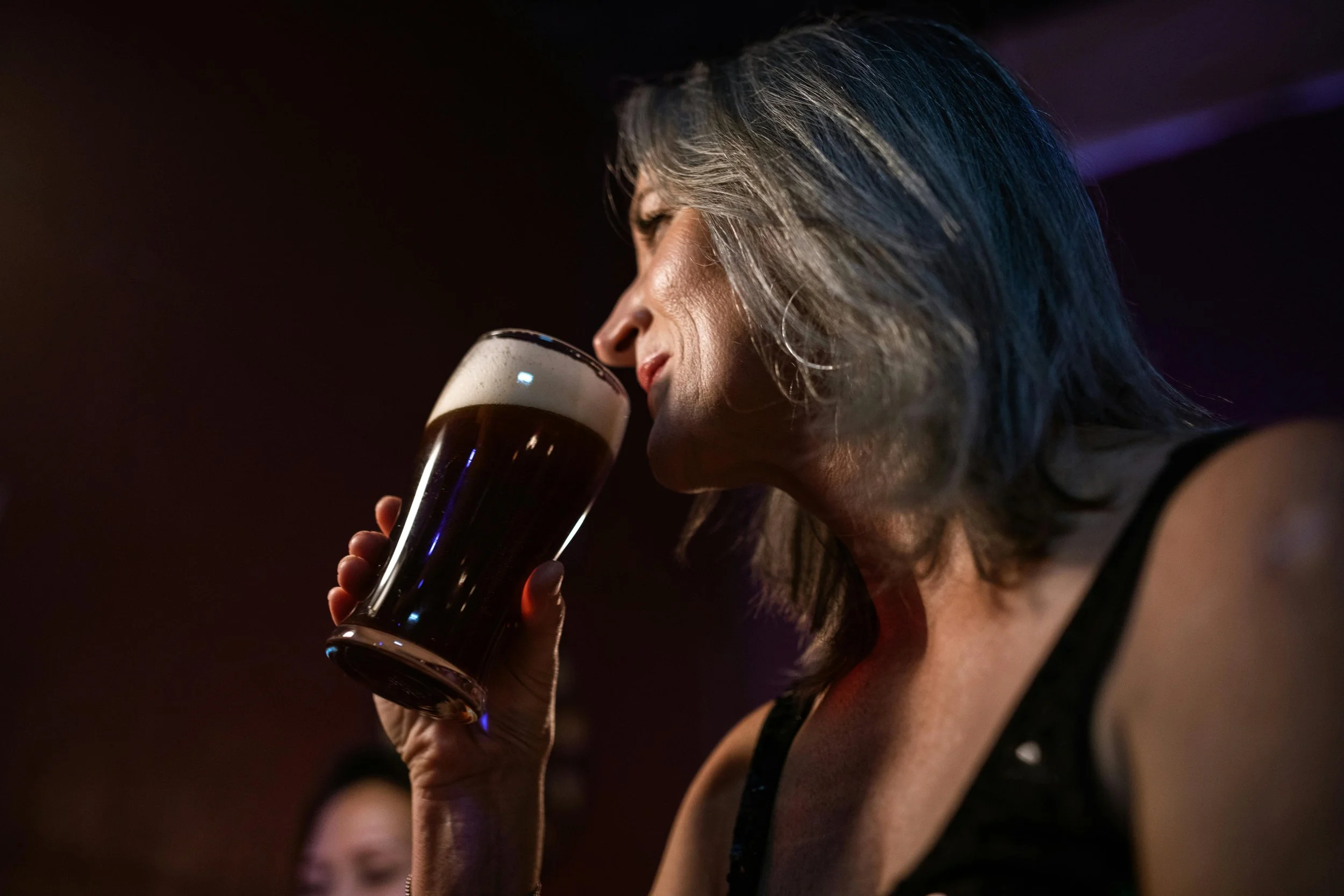 Person drinking a glass of beer