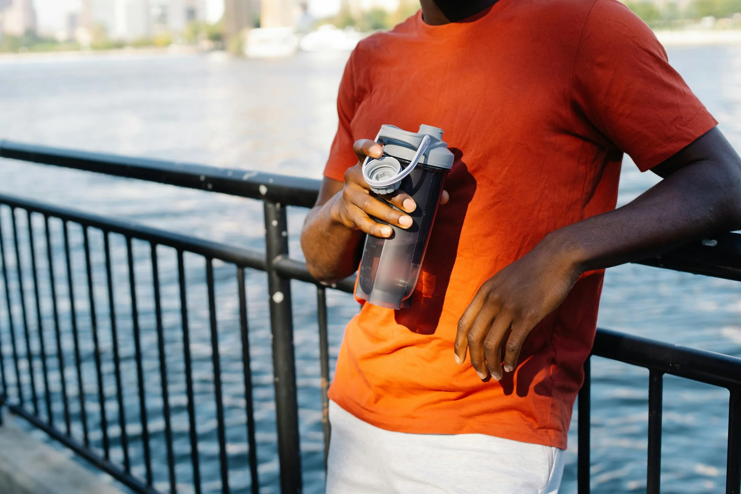 Person holding a water bottle while standing outside