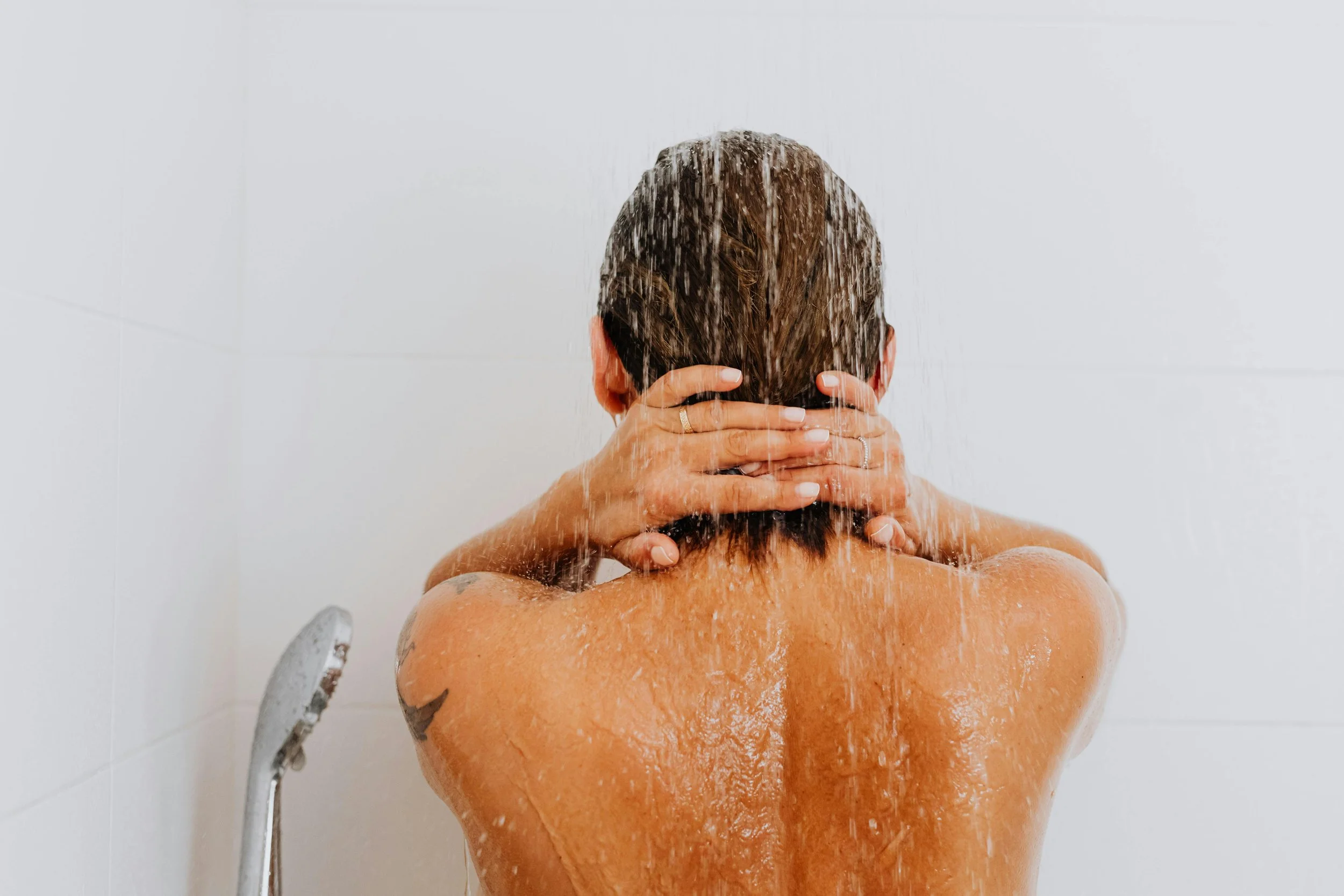 Person taking a cold shower for mental wellness