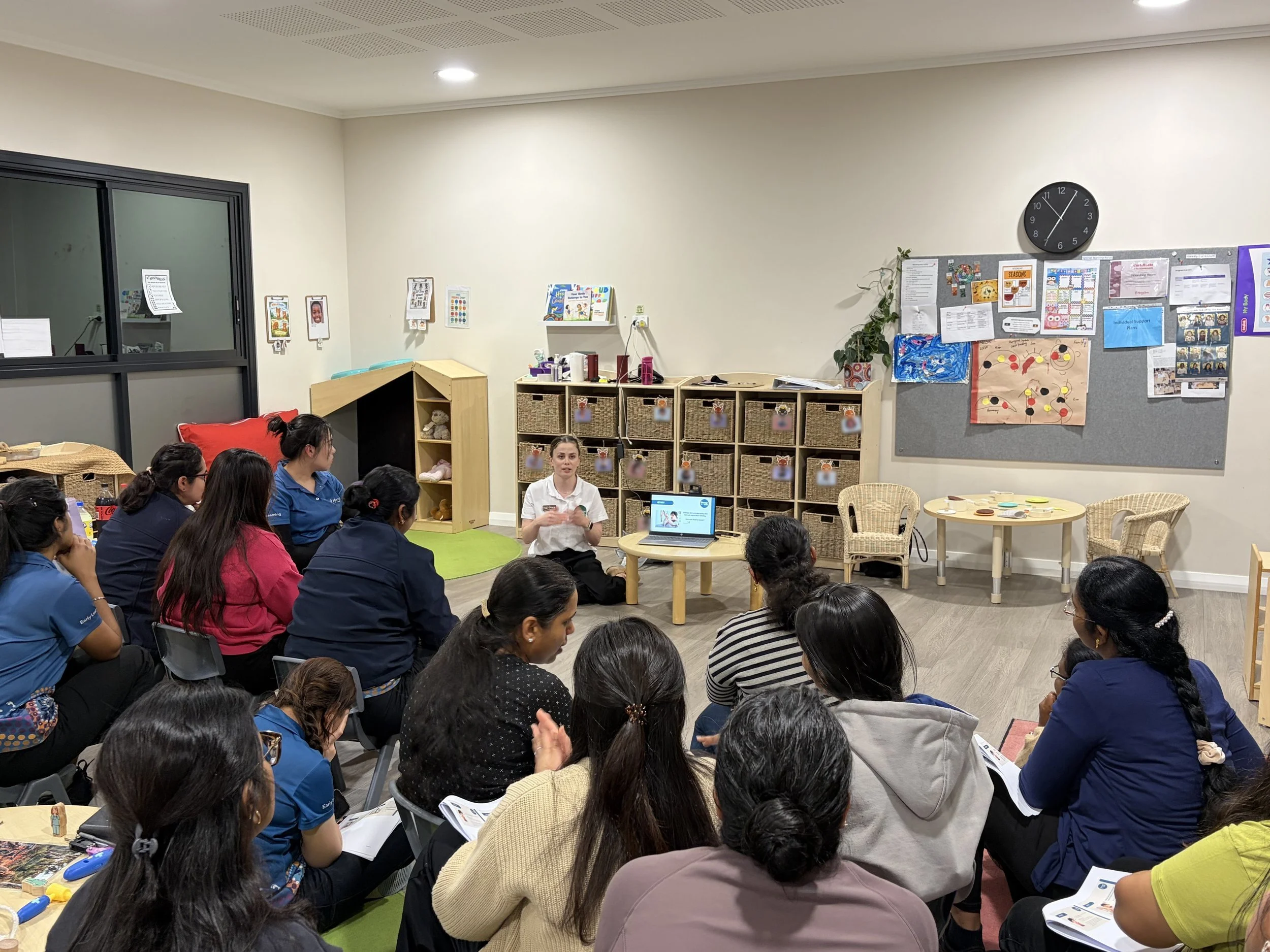 A Therapy for Kids Perth clinician running a workshop for a group of early learning educators seated around her in a classroom.