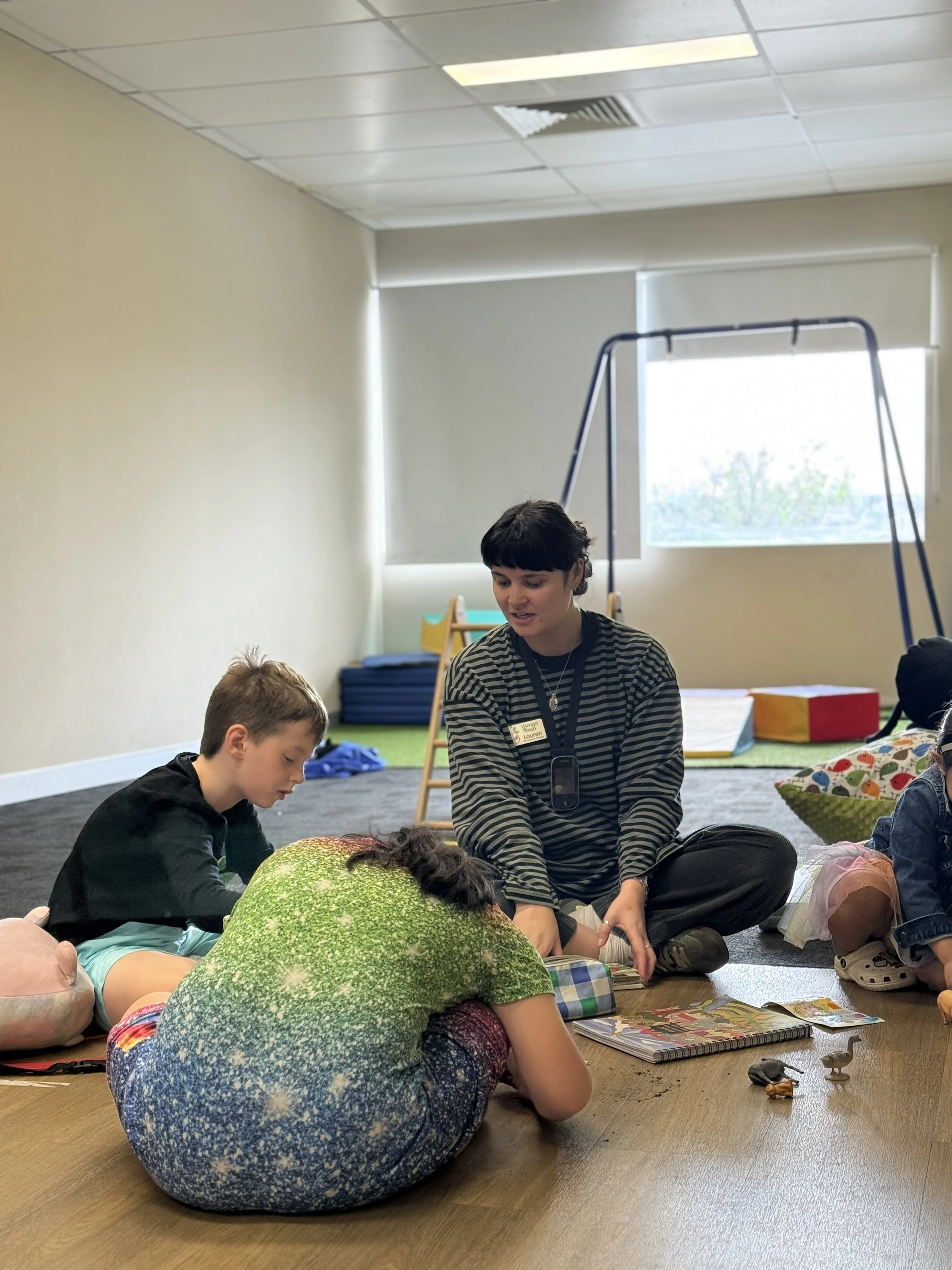 Therapist working with children on the floor