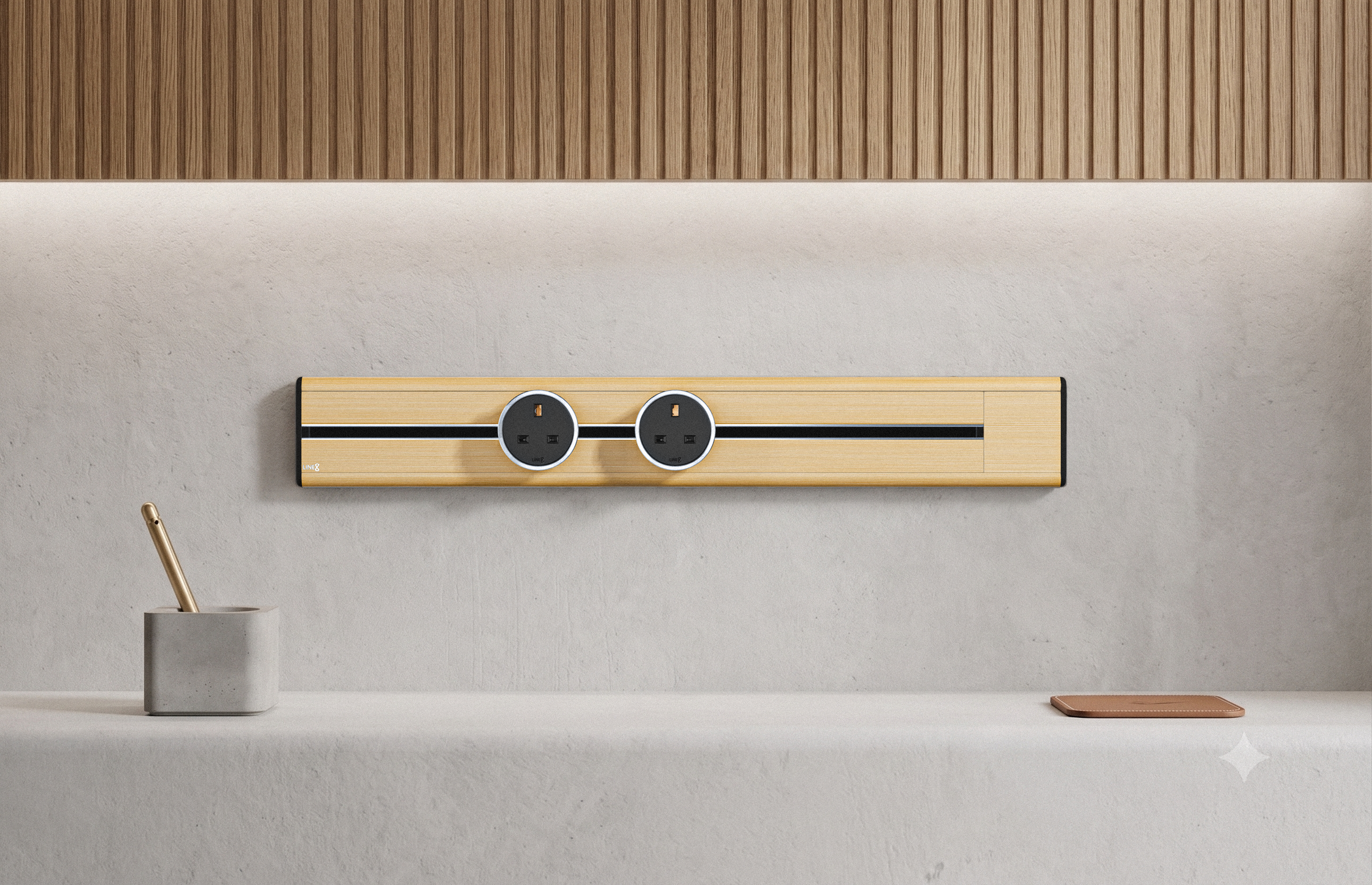 Premium Line8 Model SL electrical power track showcasing a natural American Spruce finish. Mounted against a light, textured wall beneath a warm, wood-slatted architectural panel, the high-end fitting features a contrasting black center channel and two circular black power adaptors. The track is positioned elegantly above a clean, minimalist countertop styled with a modern concrete pen holder and subtle desk accessories.