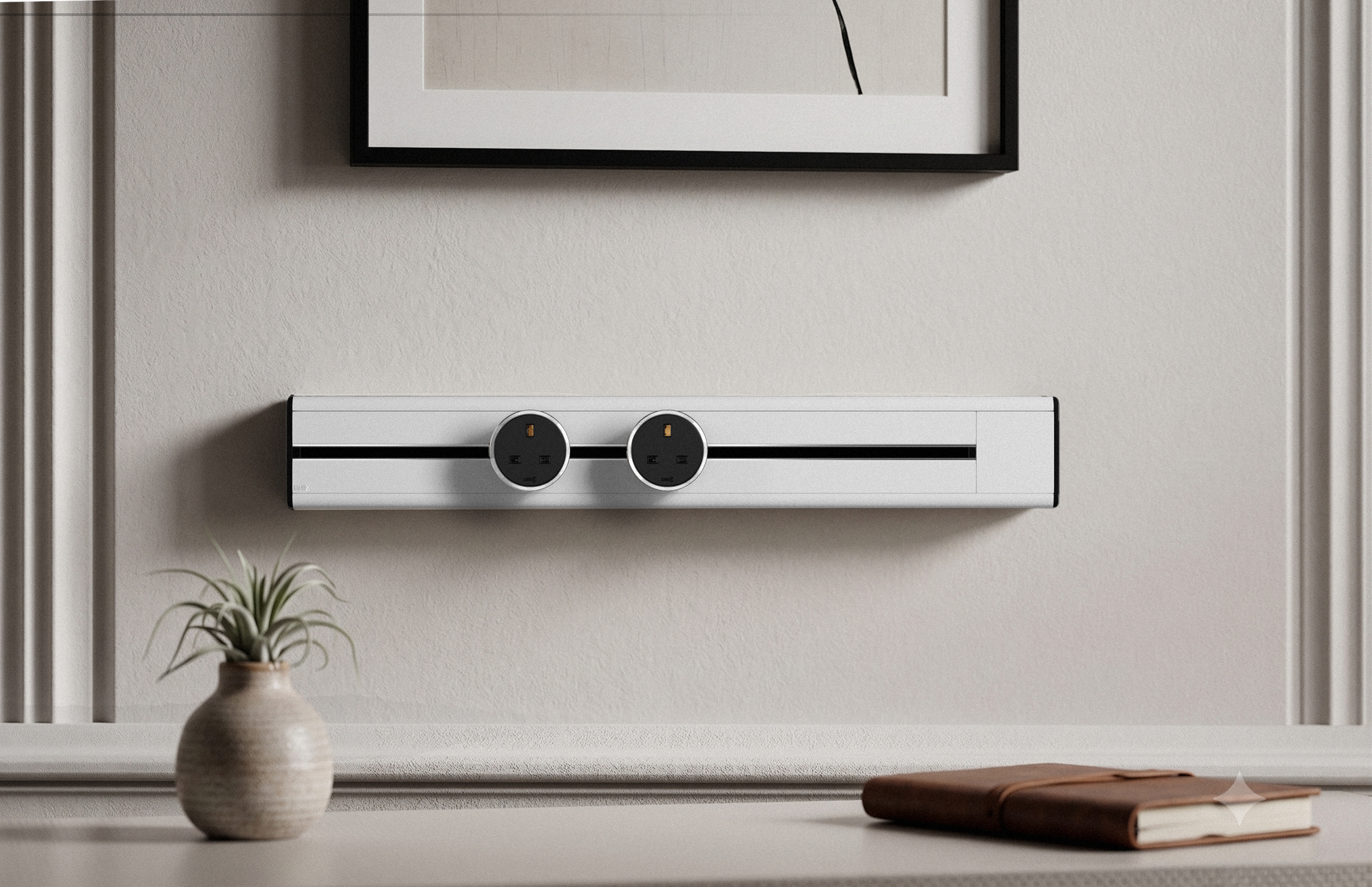 Premium Line8 Model SL electrical power track showcasing a pristine Pearl White finish. Mounted against an elegant light grey wall with classic panel molding and positioned just below a framed artwork, the high-end architectural fitting features a contrasting black center channel and includes two circular black power adaptors. The track seamlessly integrates above a clean, minimalist surface, thoughtfully styled with a small ceramic vase holding a plant and a brown leather-bound journal.