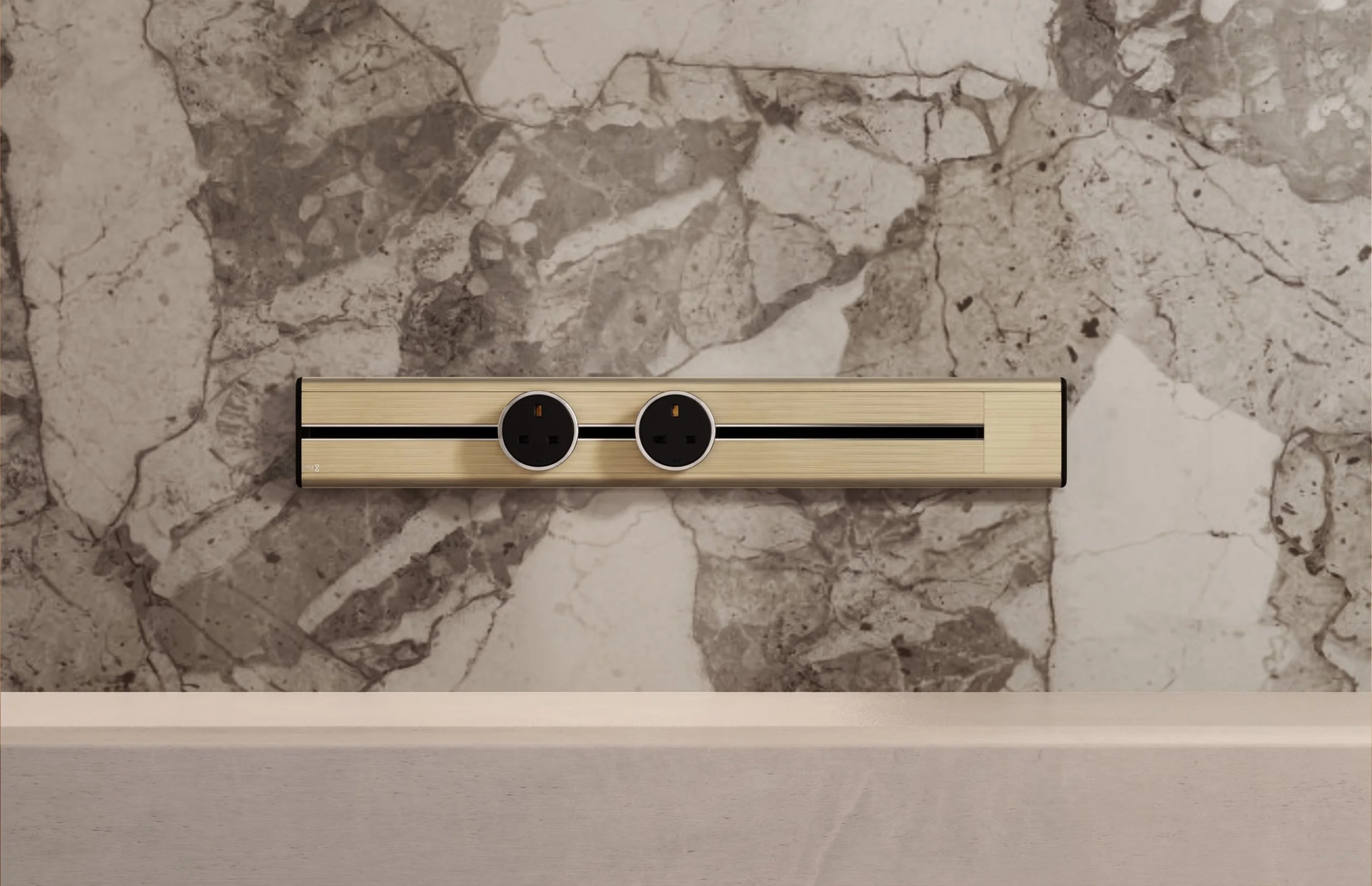 Premium Line8 Model SL electrical power track showcasing an elegant Champagne Gold finish. Mounted against a sophisticated, heavily veined natural marble wall, the high-end architectural fitting features a contrasting black center channel and includes two circular black power adaptors, positioned perfectly above a clean, minimalist countertop.