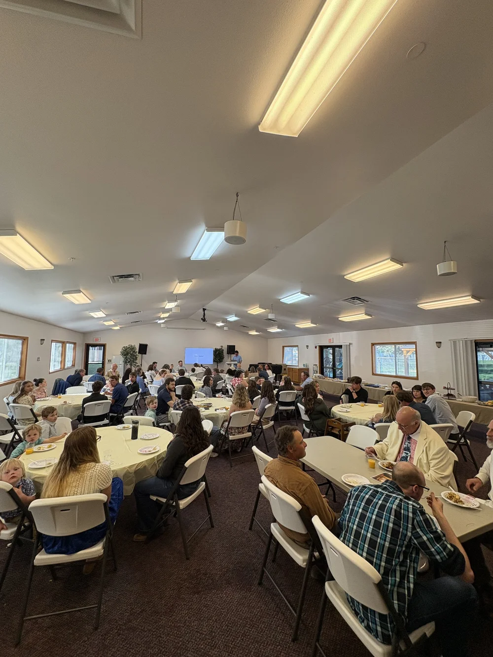 Church members gathered around fellowship tables.