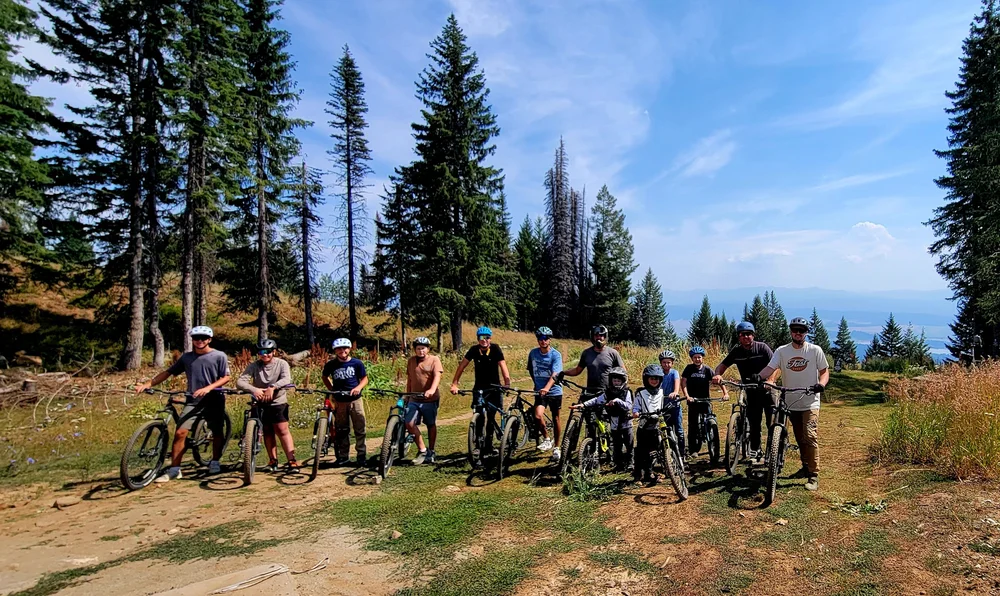 PBC friends with bicycles on a mountain trail.
