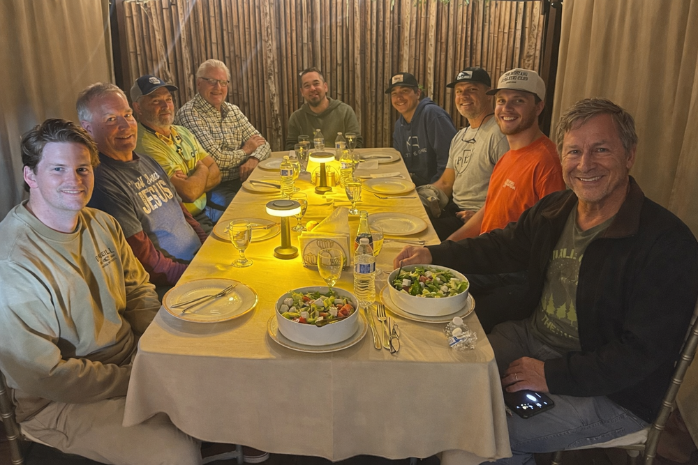 PBC friends sharing a meal around a restaurant table.