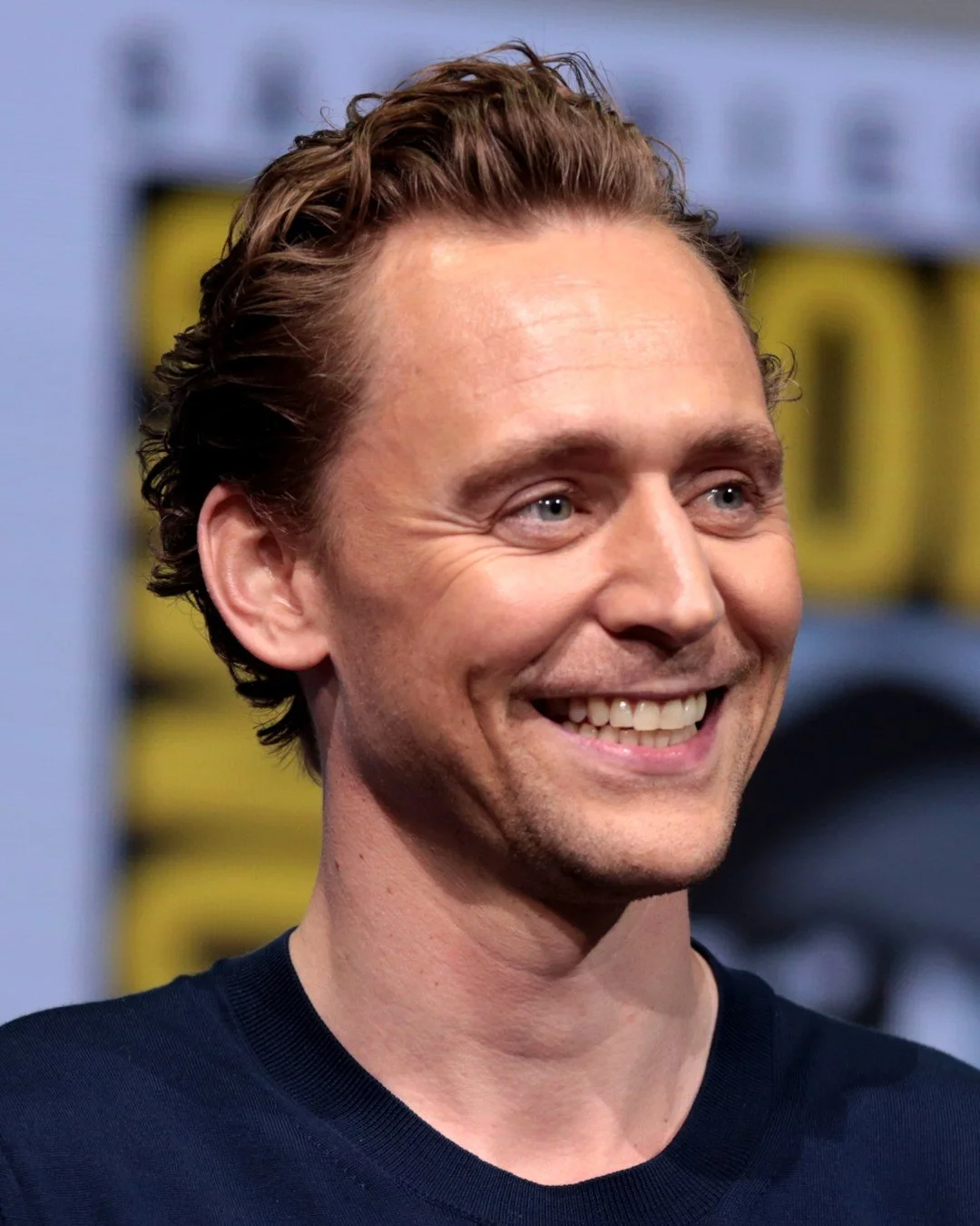 Tom Hiddleston smiling at the 2017 San Diego Comic-Con panel.