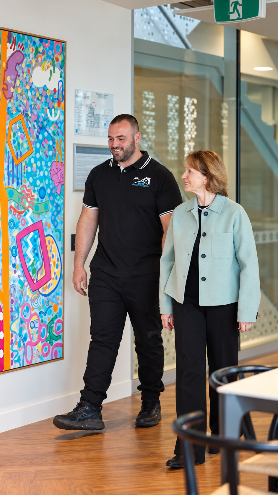 Anthony walking with Gail beside colourful artwork at Chris O’Brien Lifehouse