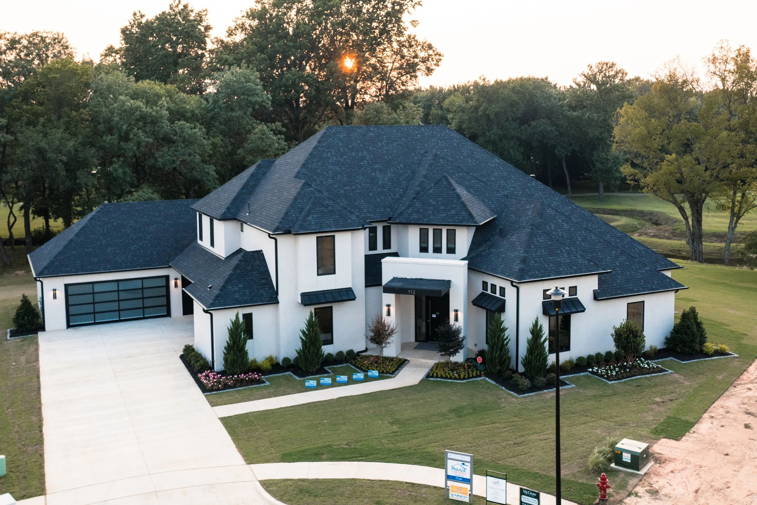 Photo of a two story white home with a drive way from an aerial view